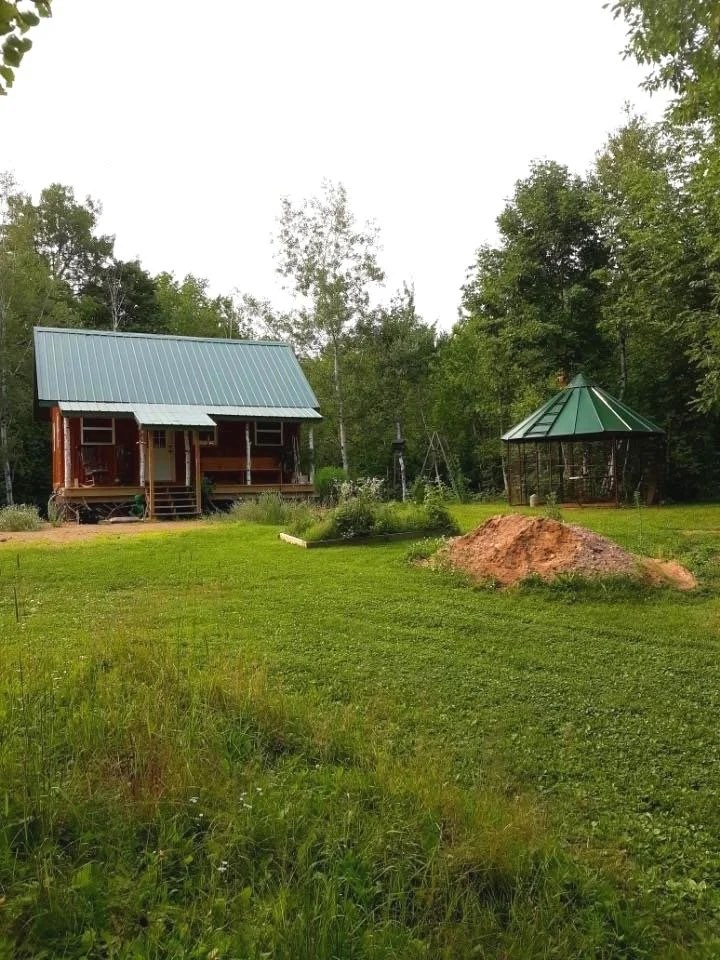 The main cabin and the corn crib across a rough field